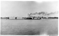 Steam boat pushing a barge 
