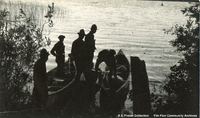 Group of men loading canoes,