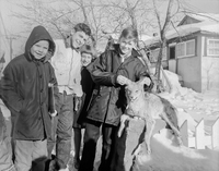 Children with what appears to be a dead coyote 