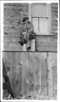 Man in Hat and Overcoat on steps of Ross Lake Rooms