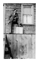 Unidentified man on steps of Ross Lake Rooms Flin Flon C 1932