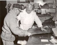  Mr Fred Kerr and a trapper measuring an animal skin on a counter 1960