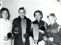 Mixed curling team posing with trophies.