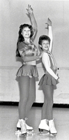 Pair of girl figure skaters posing.