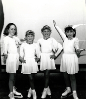 Four young girls skaters posing in their costumes.