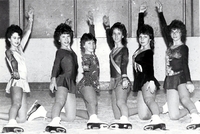 Group of young lady skaters striking a pose on the ice.