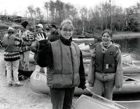 Group of young canoe paddlers on shore.