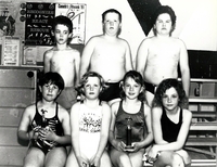 Young swimmers group photo some with trophies.