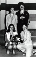 Group photo of swimmers with trophy and medals.