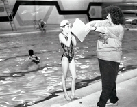 Young swimmer receiving instruction from instructor.
