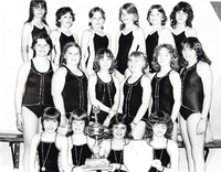 Group photo of young lady swimmers with their trophy and medals.