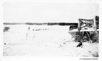 Dog Team, May be Floin Flon lake with one of the Bottom Dum;ng Barges on right C 1928