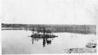 View of the little Island off shore of the Flin Flon Mine. Killarney Island in Background Possibly one of the Centre Dump Bardges Lower Right C 1929