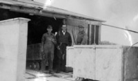 Three unidentified men at the No. 2 Shaft west door where rock was loaded into the barges for the dam. C 1927