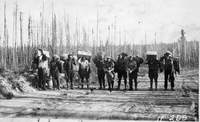 ten men on portage with packs