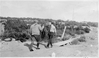 two men carrying catch of fish