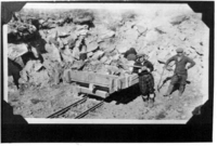Hand Mucking broken rock at blast face